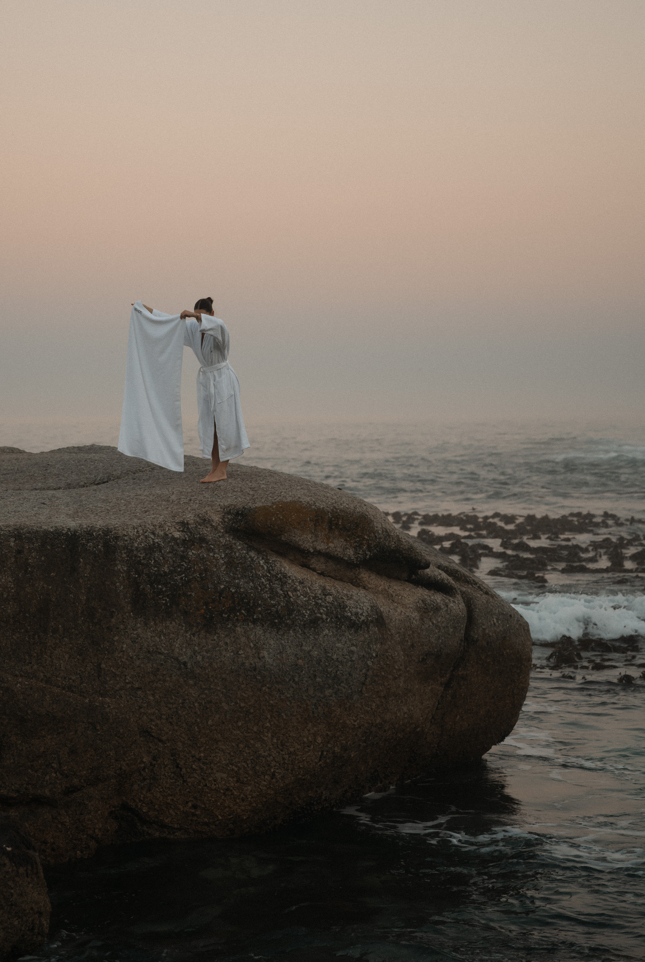 Dover towel on a coastal boulder at dusk